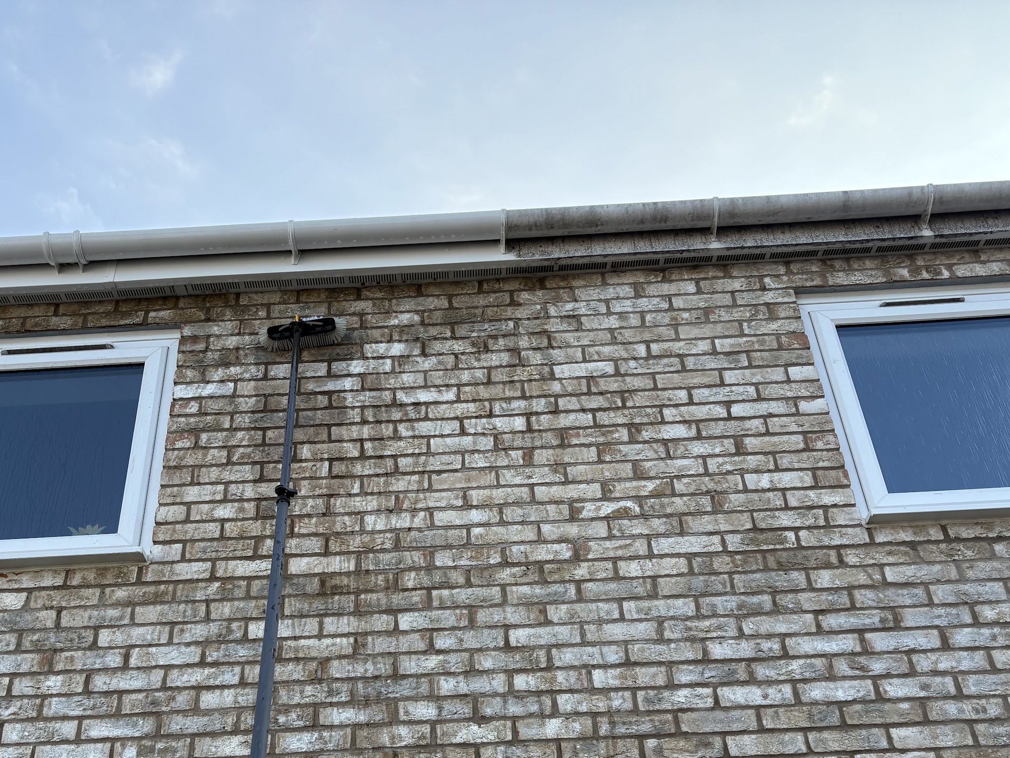 Water-fed pole at the gutter line of a brick bungalow