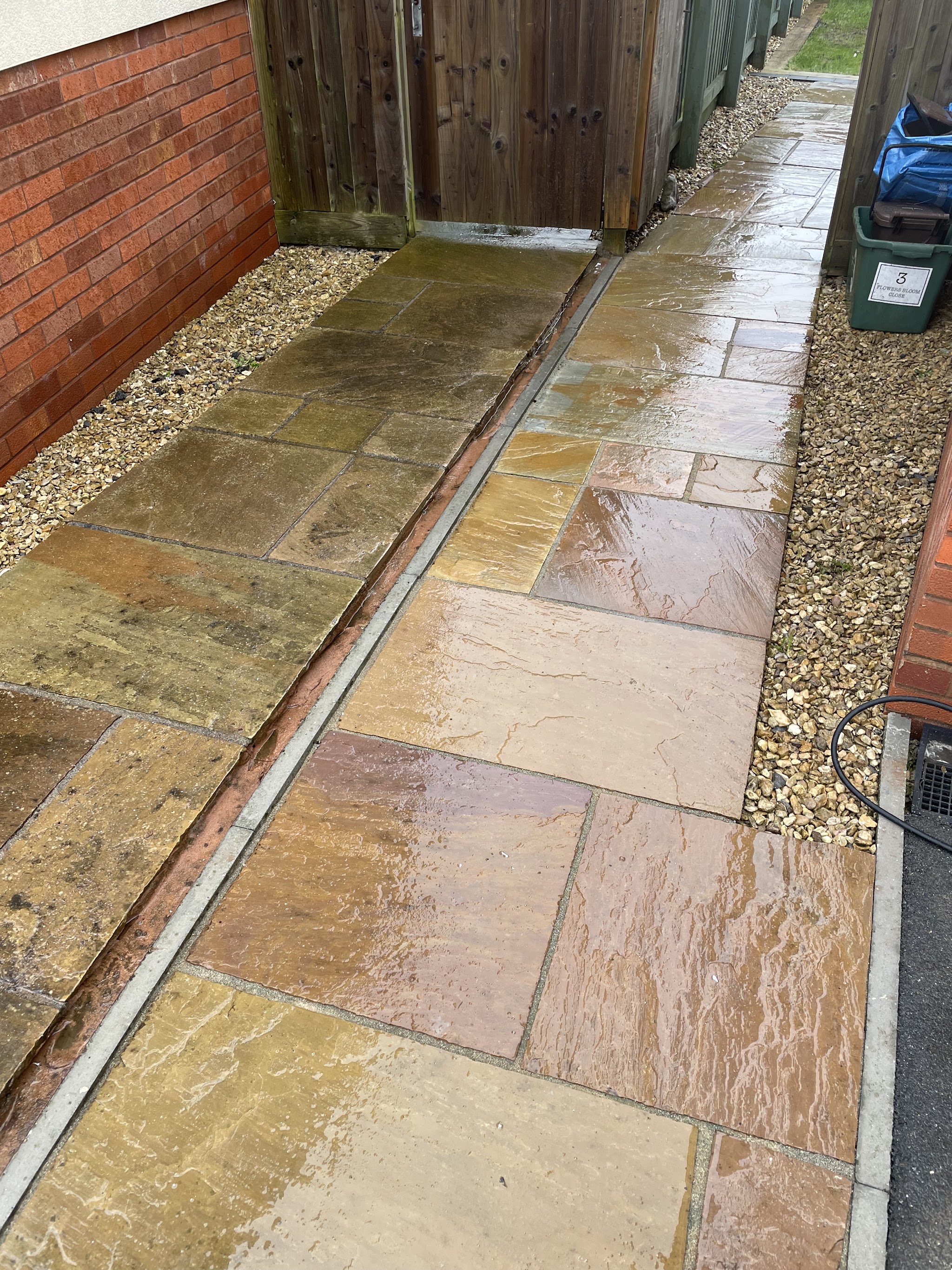 Freshly cleaned sandstone paving path beside a house